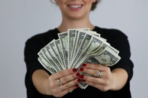 selective focus photography of woman holding US dollar banknotes